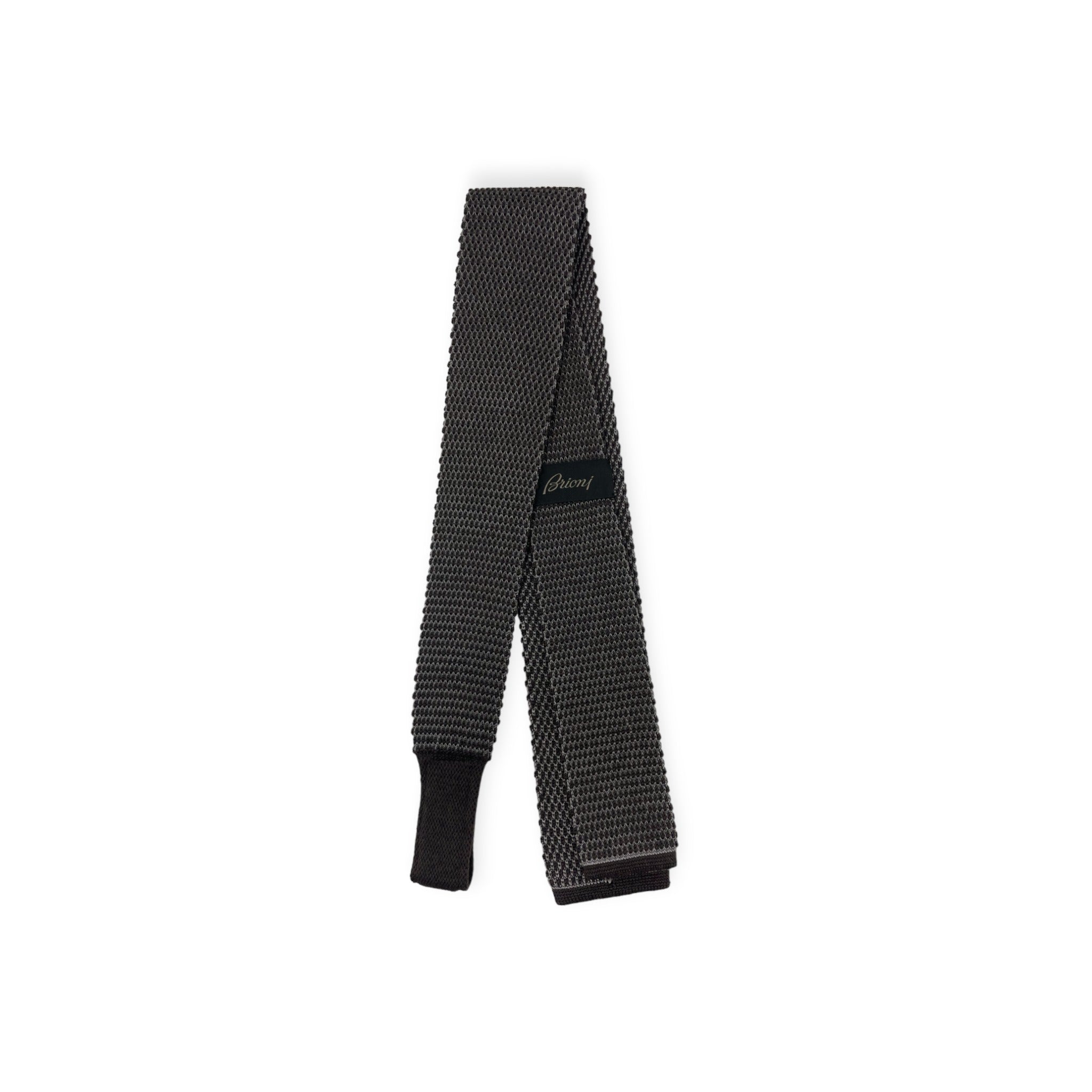 Top down view of the front of black Brioni knit tricot tie showing label