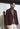 Model wearing burgundy suit with maroon turtleneck and white pants all made by Zegna