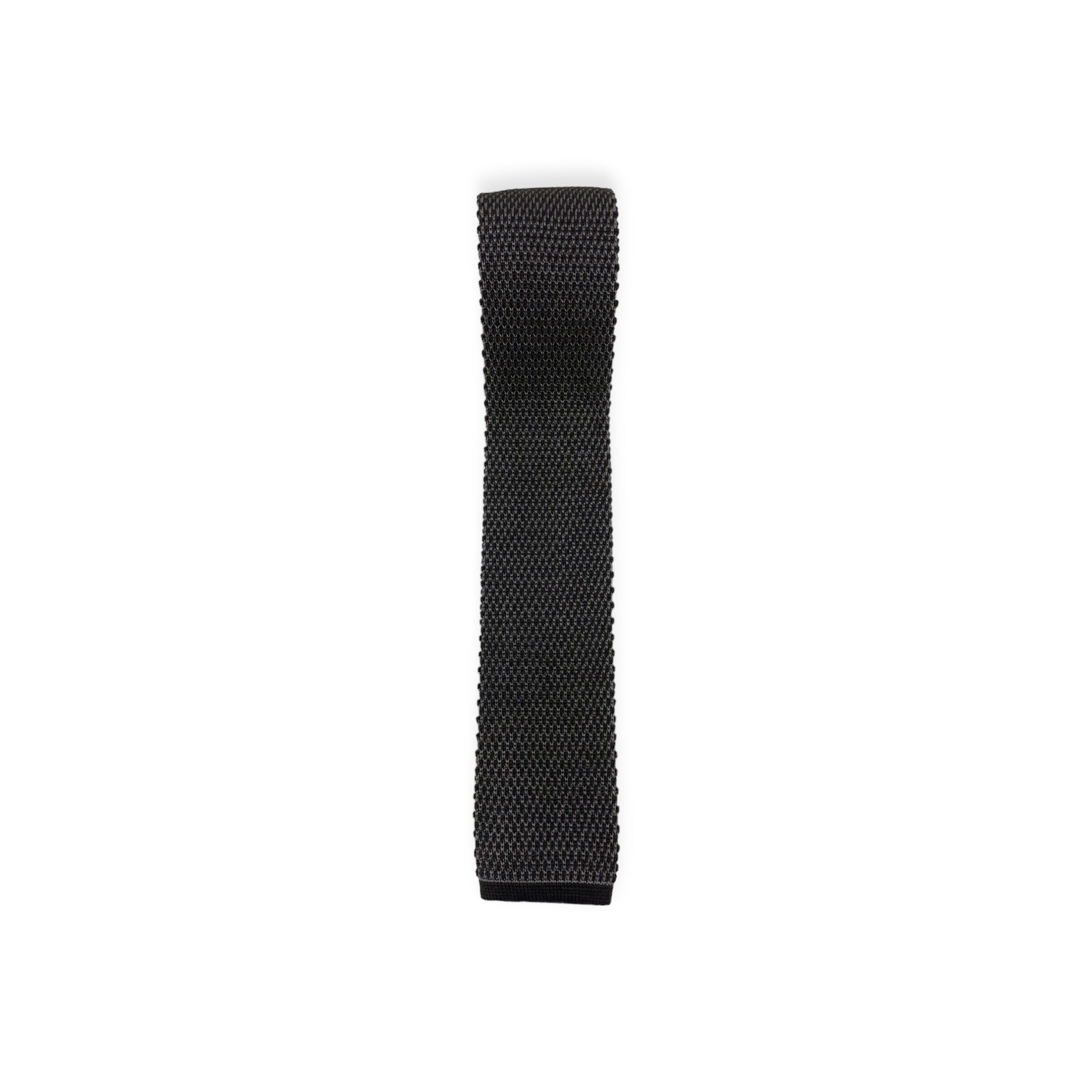 Top down view of black Brioni knit tricot tie with one side rolled