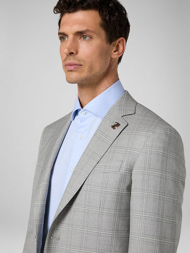 Side view of model wearing Pal Zileri grey check suit with blue dress shirt